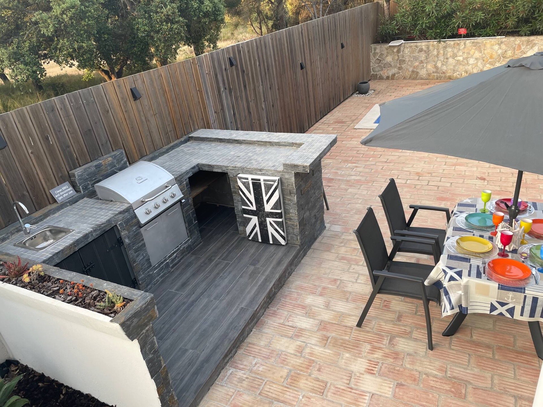 Stone-built outdoor kitchen and bar by day